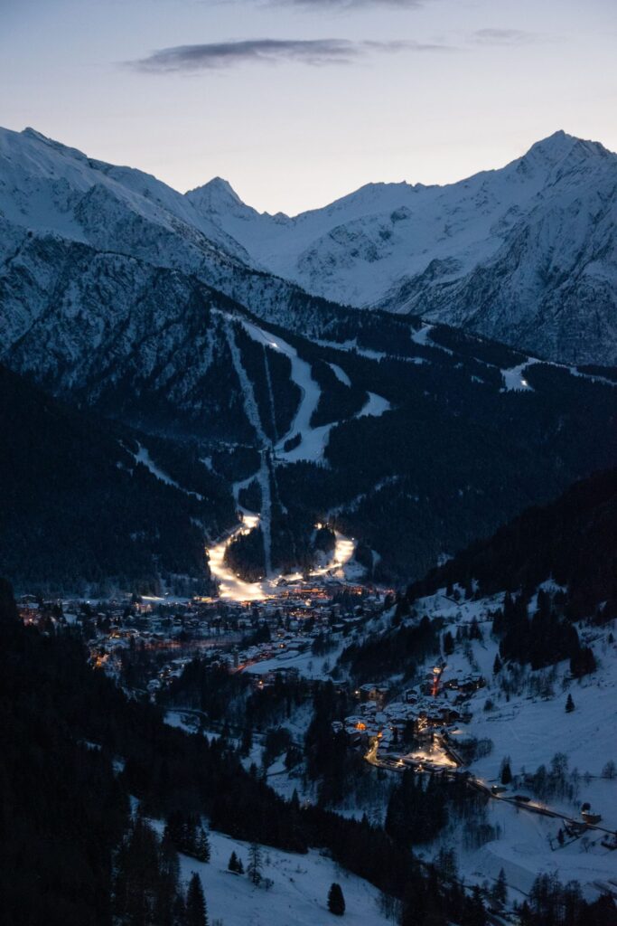 Ski town in a valley lit up at dusk
